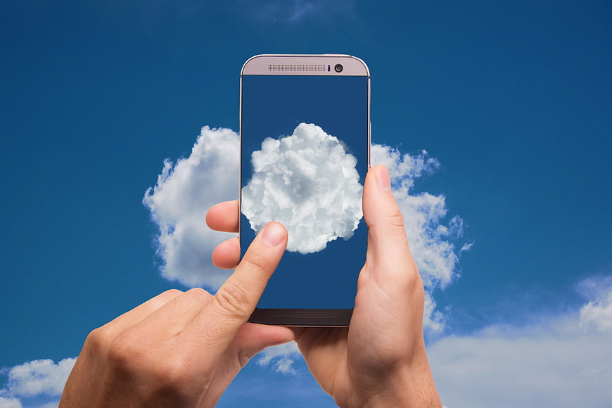 Hand holding smartphone with cloud computing concept on screen
