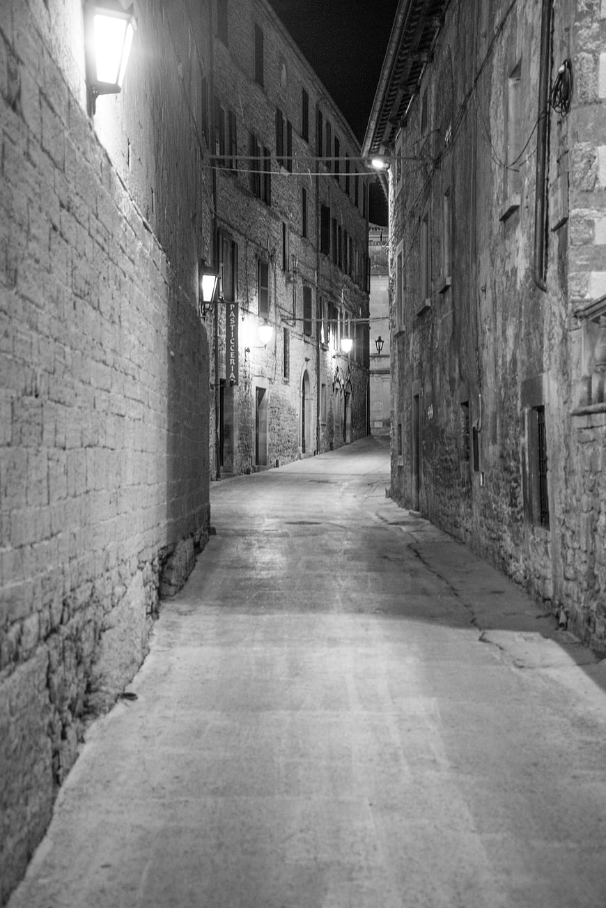 Empty cobblestone street in San Marino at night black and white