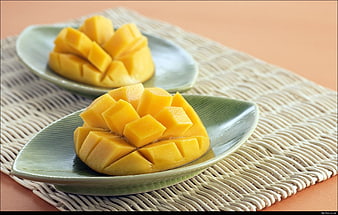 Sliced Mango Halves on Green Ceramic Plates