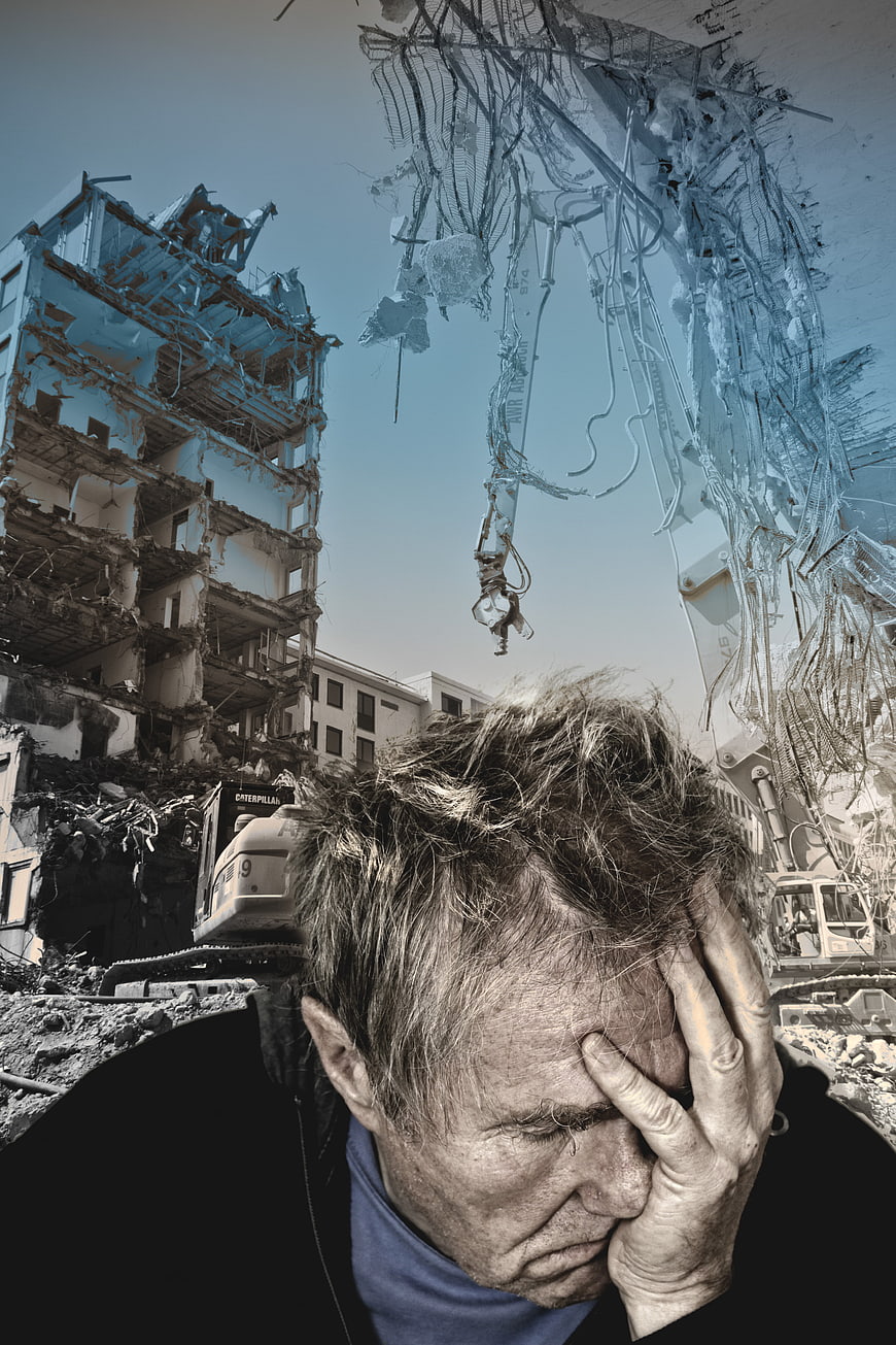 Distressed man with hand on forehead against demolition background