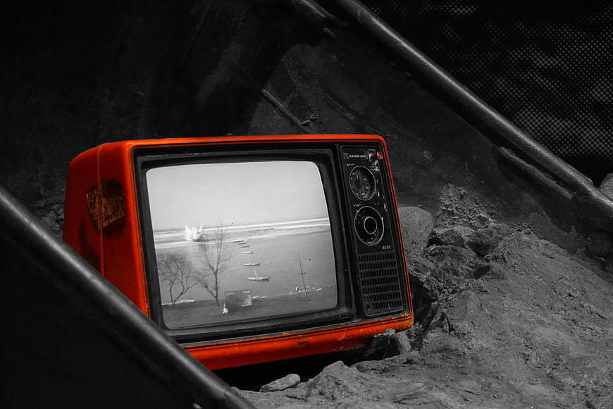 Vintage Red Television Set Abandoned in Dark Industrial Rubble