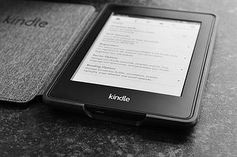 Black and white Kindle e-reader on textured surface