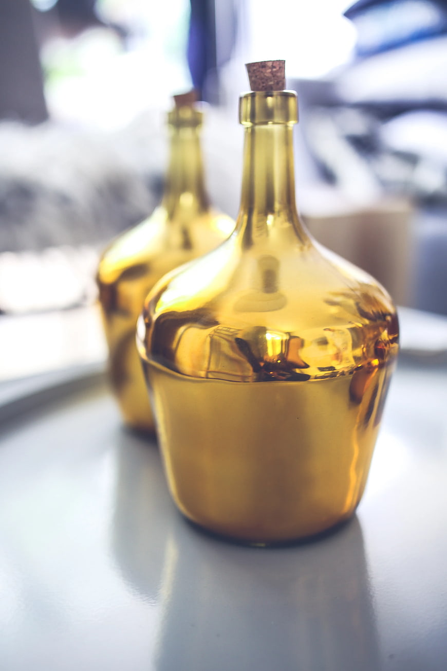 Golden glass bottles with cork stoppers on a table