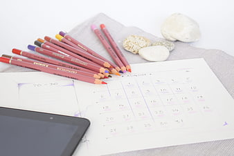 August Calendar Planner With Colored Pencils And Tablet On White Background