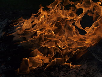 Close-up of intense orange flames burning at night