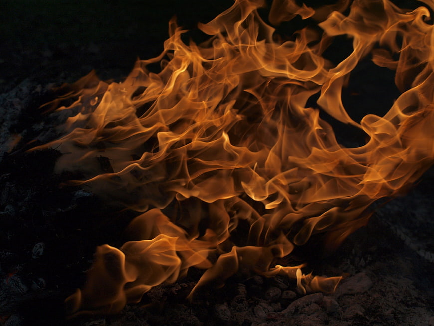 Close-up of intense orange flames burning at night