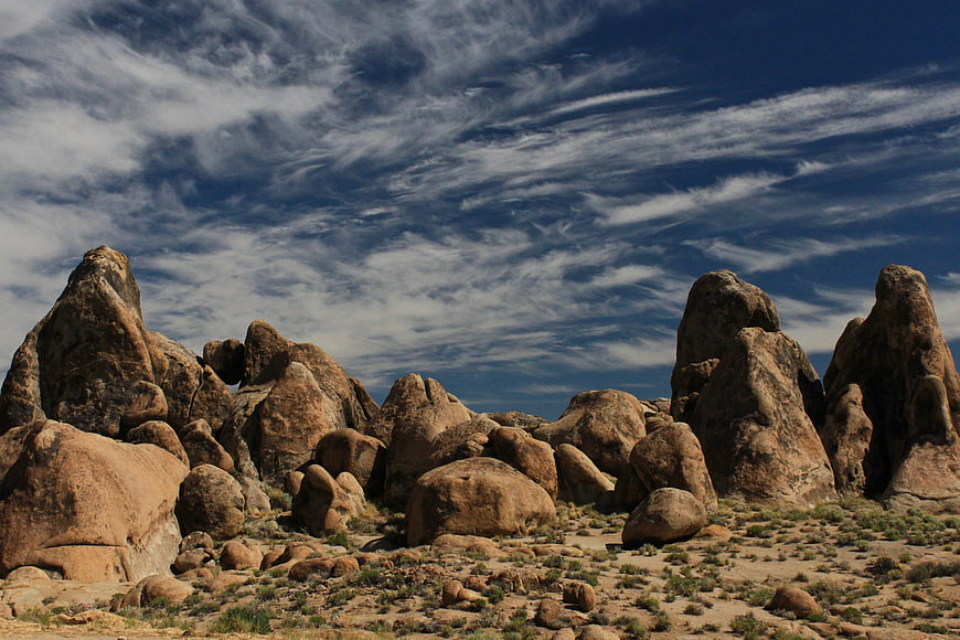Dramatic desert rock formations under blue sky with clouds