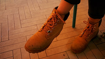 Close-up of Worn Brown Leather Work Boots on Tiled Floor