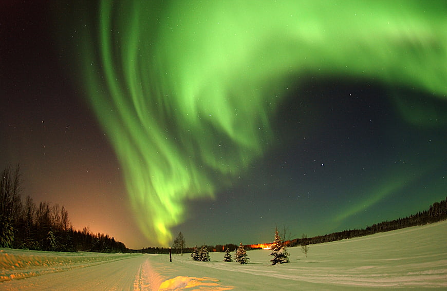 Vibrant Green Aurora Borealis Over Snowy Winter Road