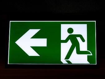 Illuminated green emergency exit sign with running man symbol