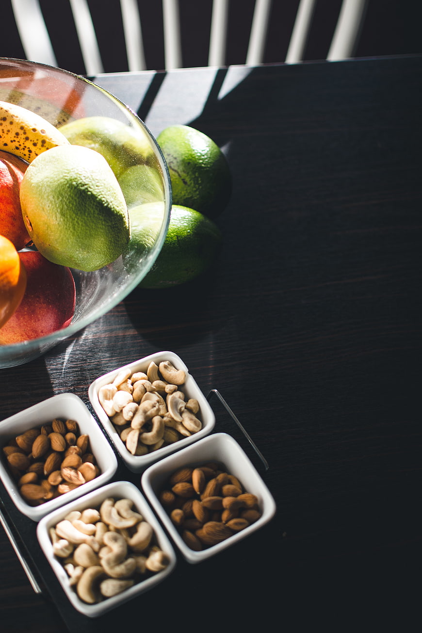 Healthy nuts and fresh fruit on dark wooden table