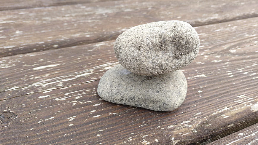 Stacked zen stones on weathered wooden background