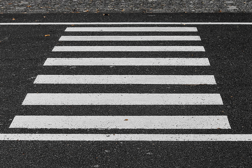 High Angle View of White Zebra Crosswalk on Black Asphalt Road