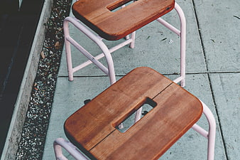 High Angle View of Wooden and Pink Metal Stools on Concrete