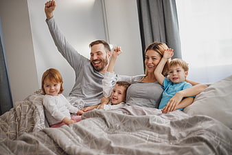 Happy family waking up together in bed