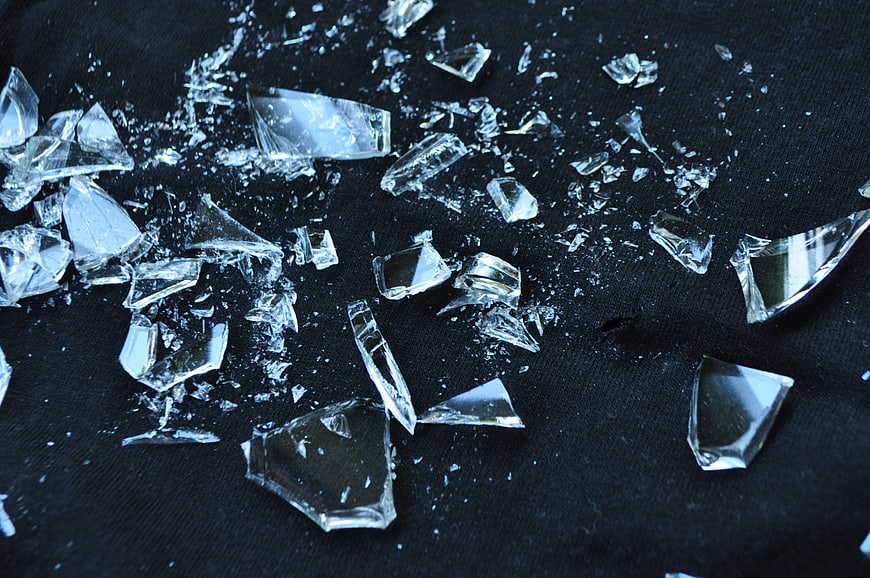 Shattered glass fragments on black textured background