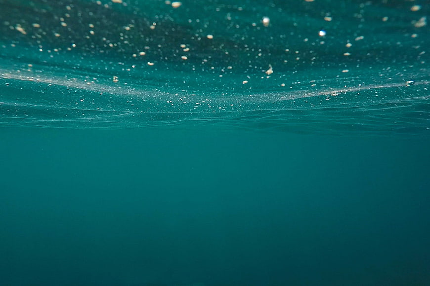 Underwater View of Turquoise Ocean Surface With Bubbles