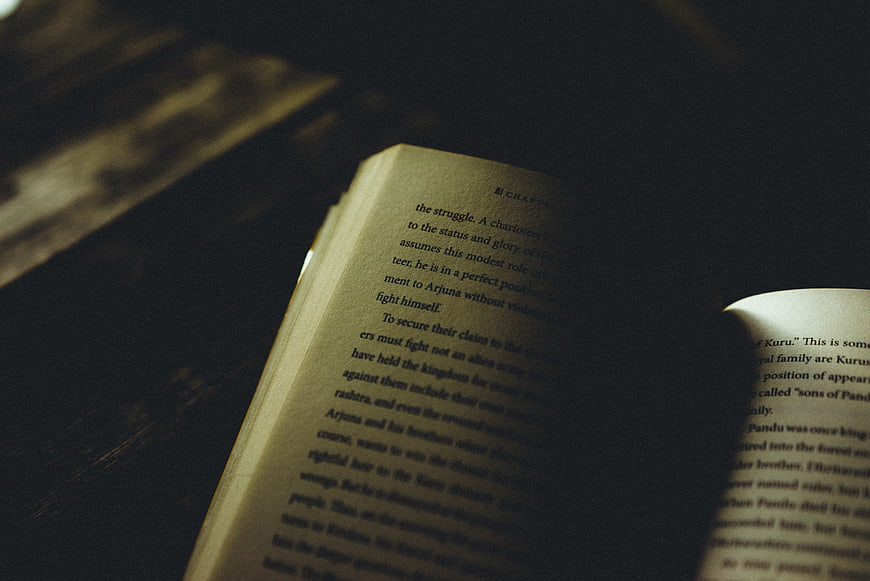 Open Book on Dark Wooden Table with Dramatic Lighting