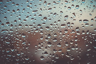 Macro Raindrops on Glass Window with Blurred Background