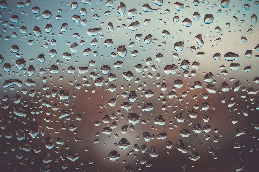 Macro Raindrops on Glass Window with Blurred Background