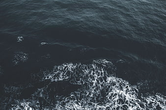 Aerial View of Dark Ocean Waves and White Sea Foam