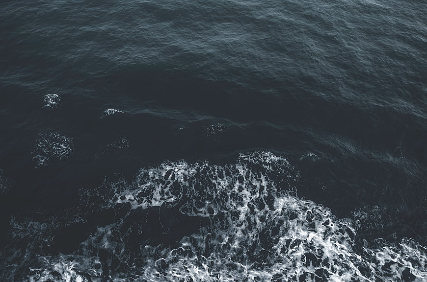 Aerial View of Dark Ocean Waves and White Sea Foam