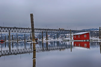 Red floating cabin reflected in calm winter harbor water