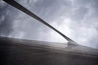 Low angle view of modern concrete bridge structure against cloudy sky