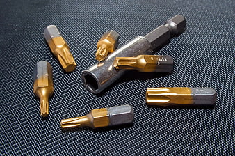 Gold and Black Torx Screwdriver Bits on Textured Mat
