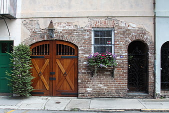 Historic brick facade with wooden gate and flower box