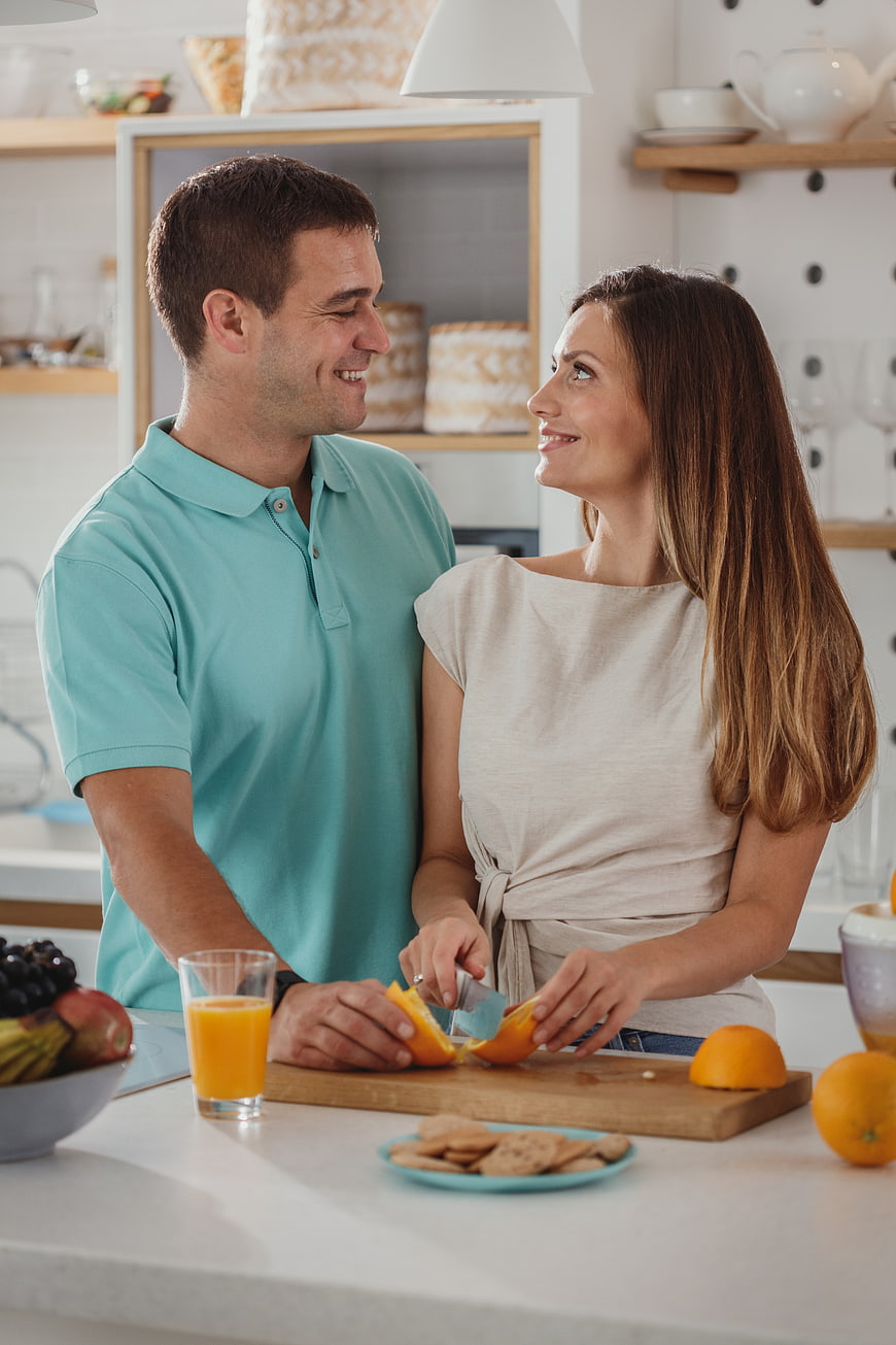 Happy couple preparing breakfast together in modern kitchen
