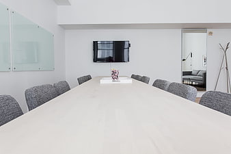Modern minimalist conference room with white table and gray chairs