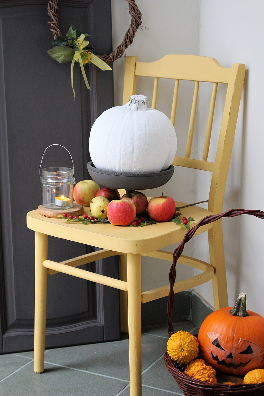 Autumn Halloween Decor with White Pumpkin and Apples on Yellow Chair