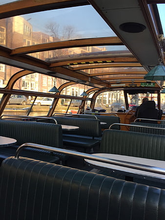 Interior of a canal boat with green leather seats in Amsterdam