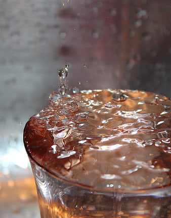 Close-up of amber liquid splash in glass