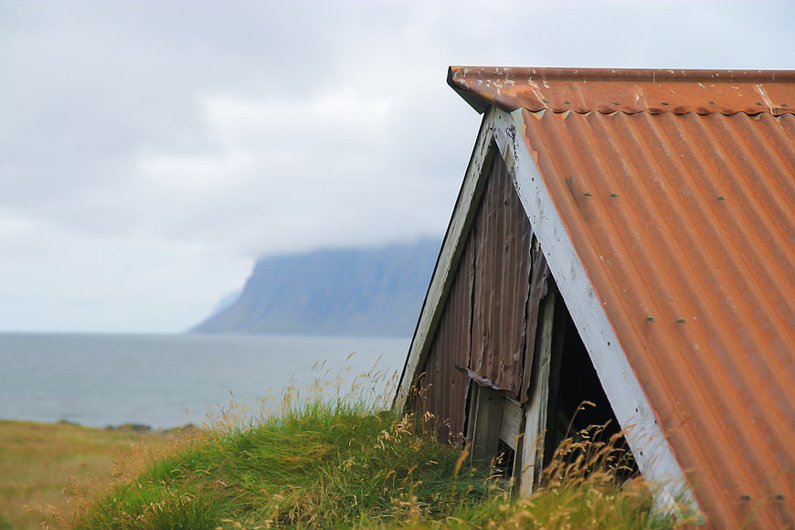 Rusty corrugated metal roof of old coastal shed with ocean view
