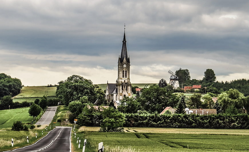 Rural Church and Windmill on Green Hillside