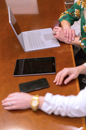 Business meeting with laptop, tablet, and smartphone on wooden table