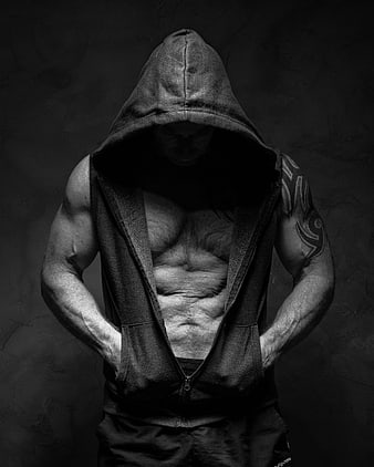 Muscular man in black hoodie with tattooed arm