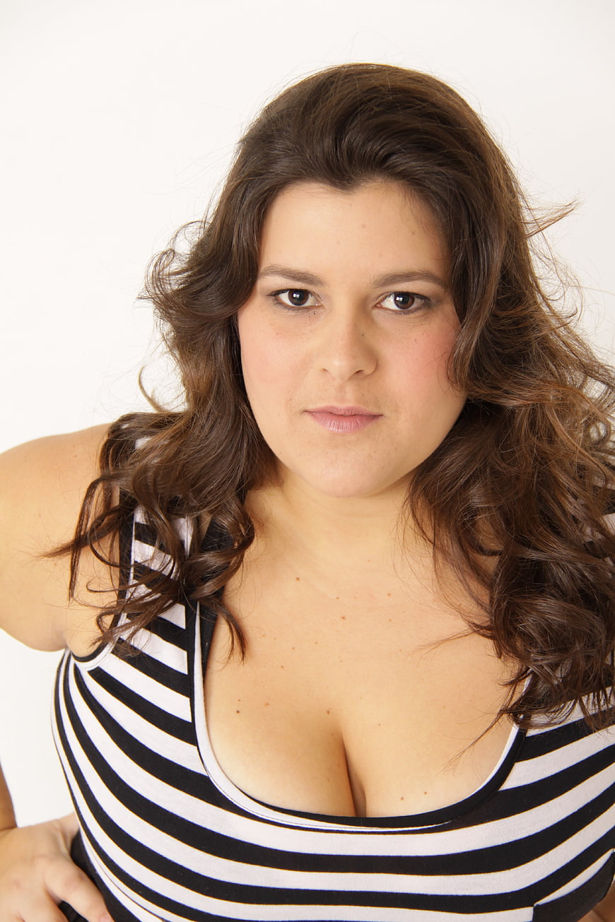 Studio portrait of a woman with wavy brown hair in a striped top
