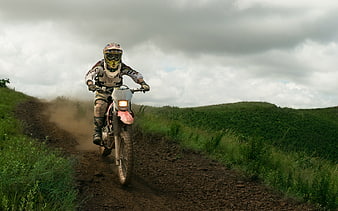 Motocross Rider on Dirt Trail in Green Hills