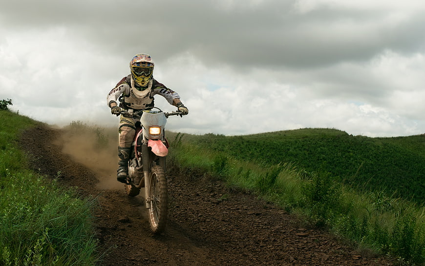 Motocross Rider on Dirt Trail in Green Hills