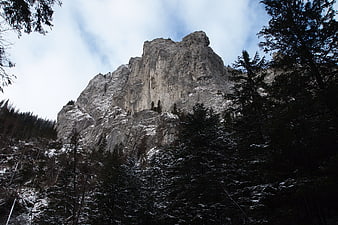 Snowy Mountain Peak Rising Above Dark Winter Forest