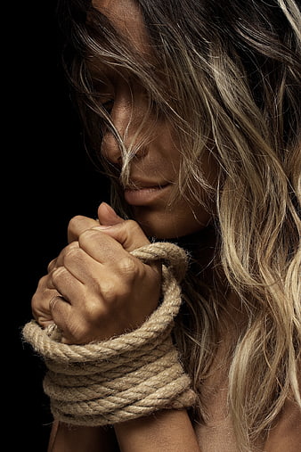 Close-up of woman with bound hands and disheveled hair