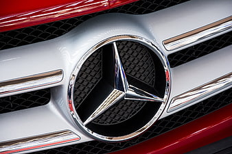 Close-up of Mercedes-Benz emblem on red car grille