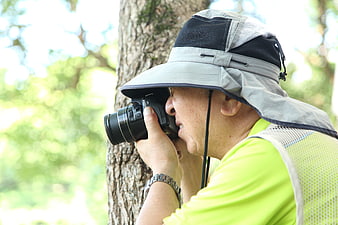 Senior man taking photos in nature with DSLR camera