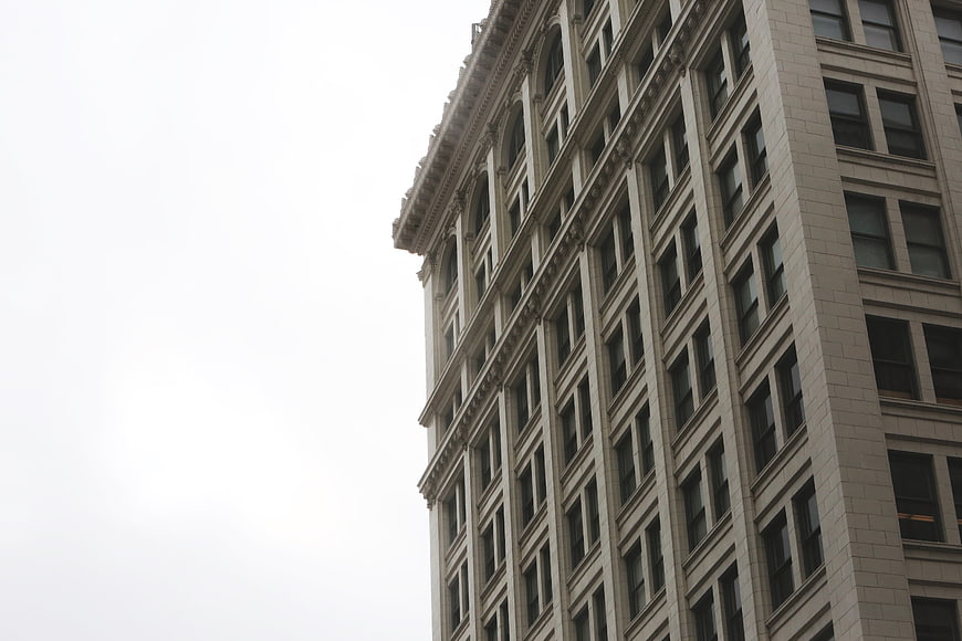Low angle view of classic urban architecture against white sky