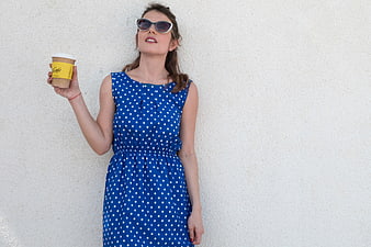 Woman in Blue Polka Dot Dress Holding Coffee Cup