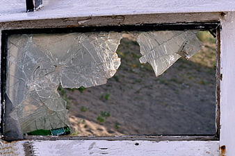 Broken window glass with green bottle in frame