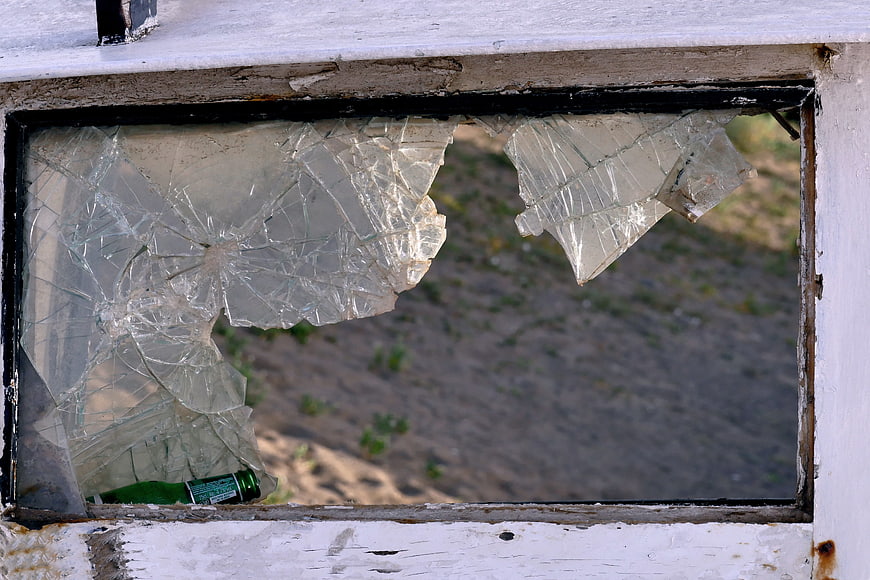 Broken window glass with green bottle in frame
